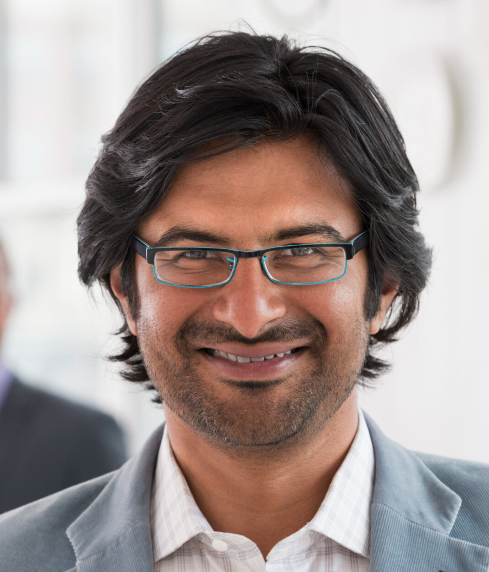 Smiling man in professional attire with glasses, representing Tech Support Austin's commitment to personalized IT solutions and client satisfaction.